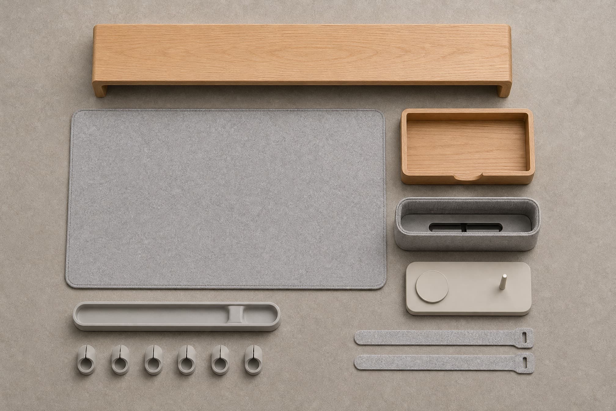 Desk kit components separated and aligned in rows on a stone-grey surface.