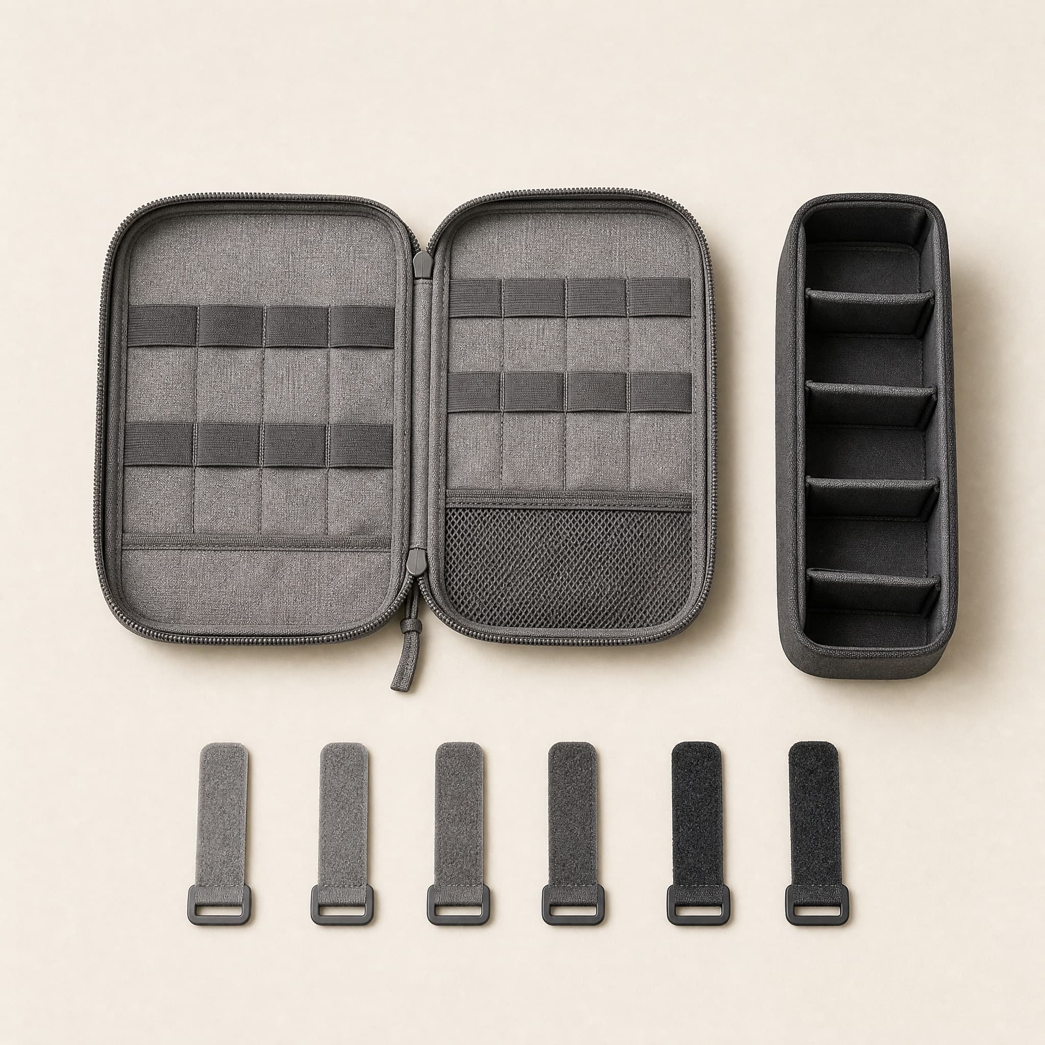 Tech Carry Kit flat lay: stone-grey woven cable pouch opened to empty elastic loops, charcoal adapter organizer and six cord ties.